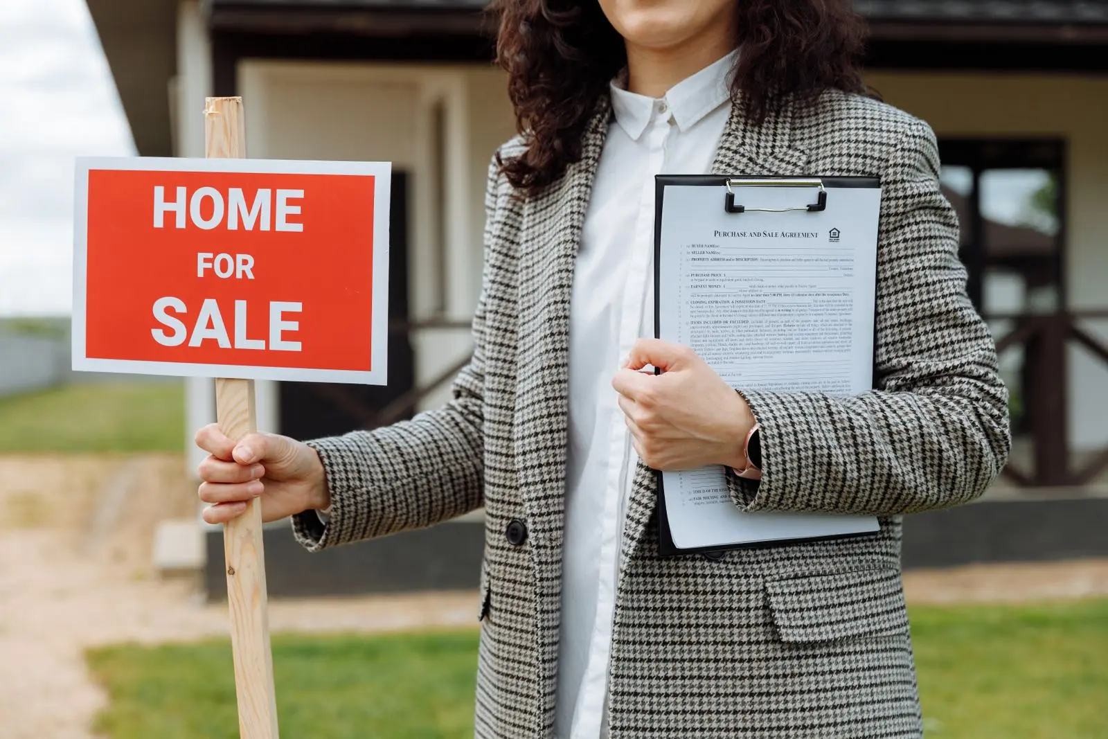 An estate agent with a home for sale board