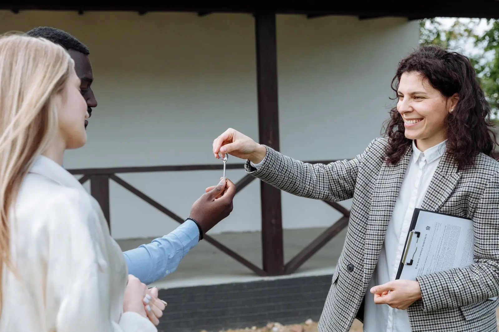 An originator handing over house keys to new owners