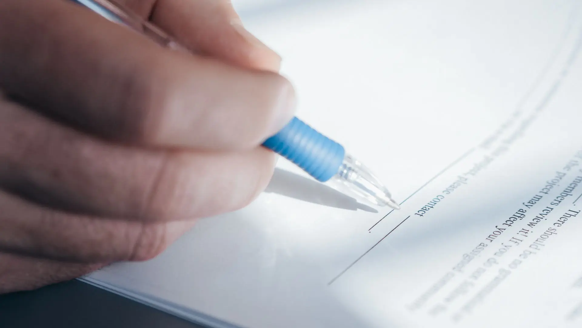 A hand signing a home loan application