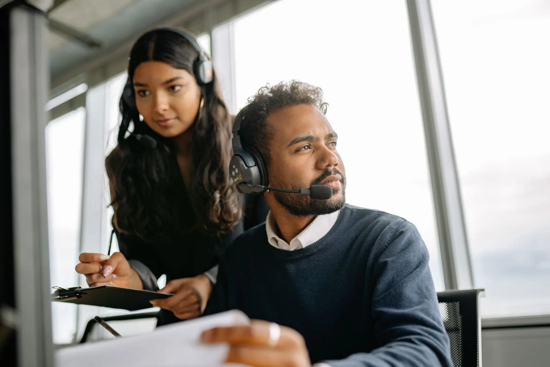 Two consultants on headsets taking calls in an office