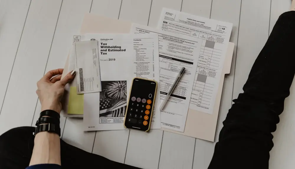Financial statements, a calculator and a laptop on a desk